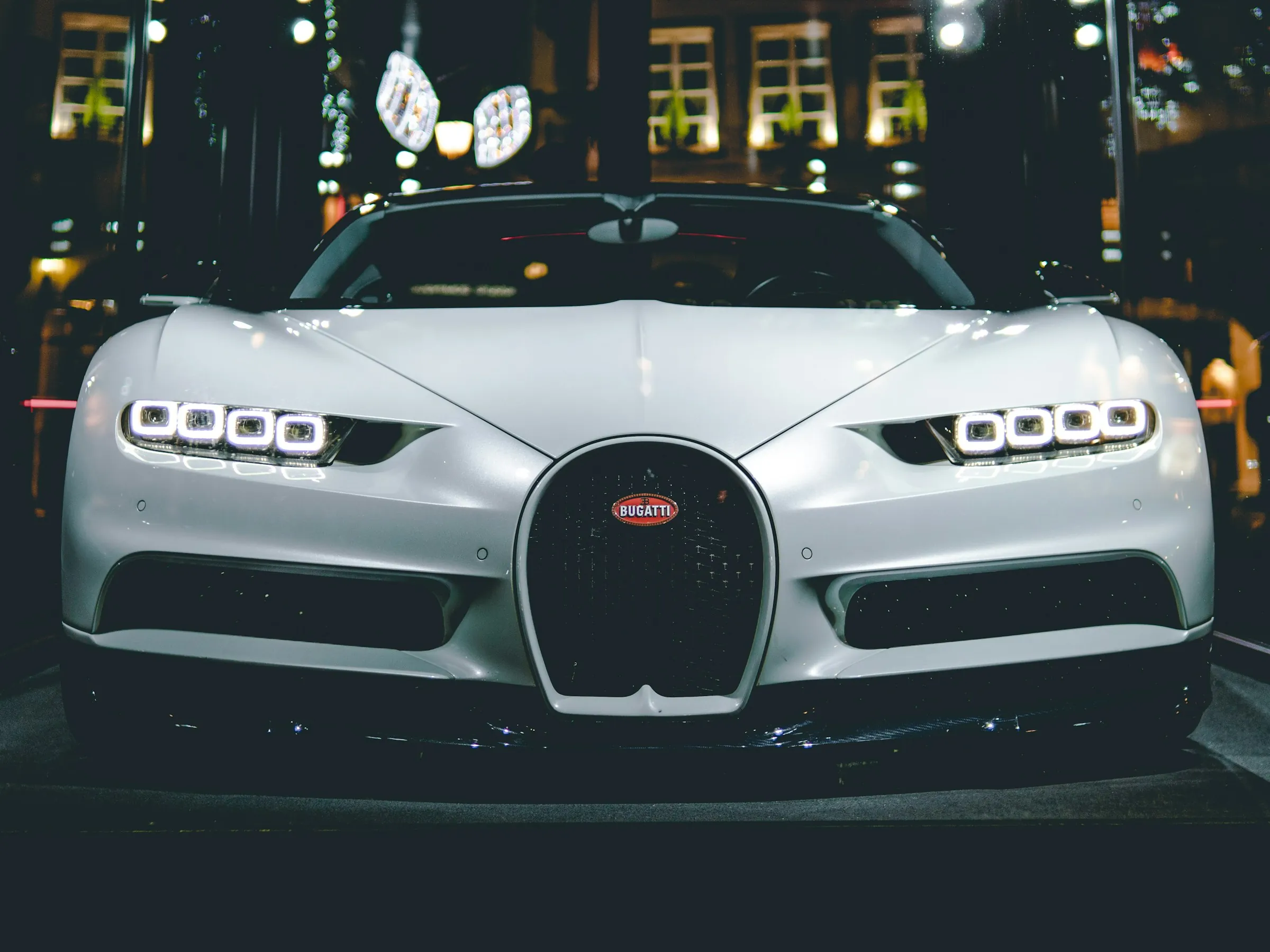 Silver hypercar front end lit at night